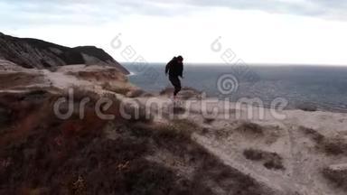 一个穿着运动服的女人在一个地方跑步的无人视野。 悬崖上的健康，无人机视野